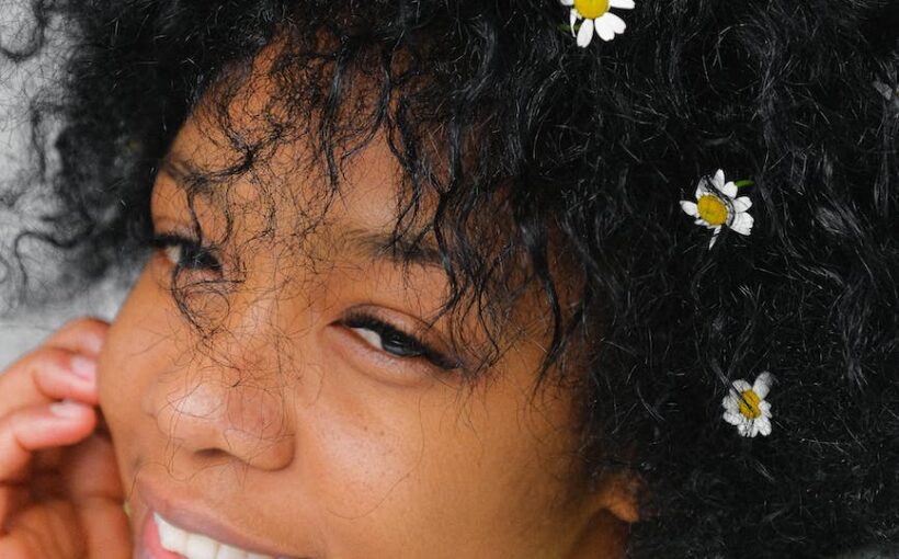 romantic black woman with chamomiles in hair